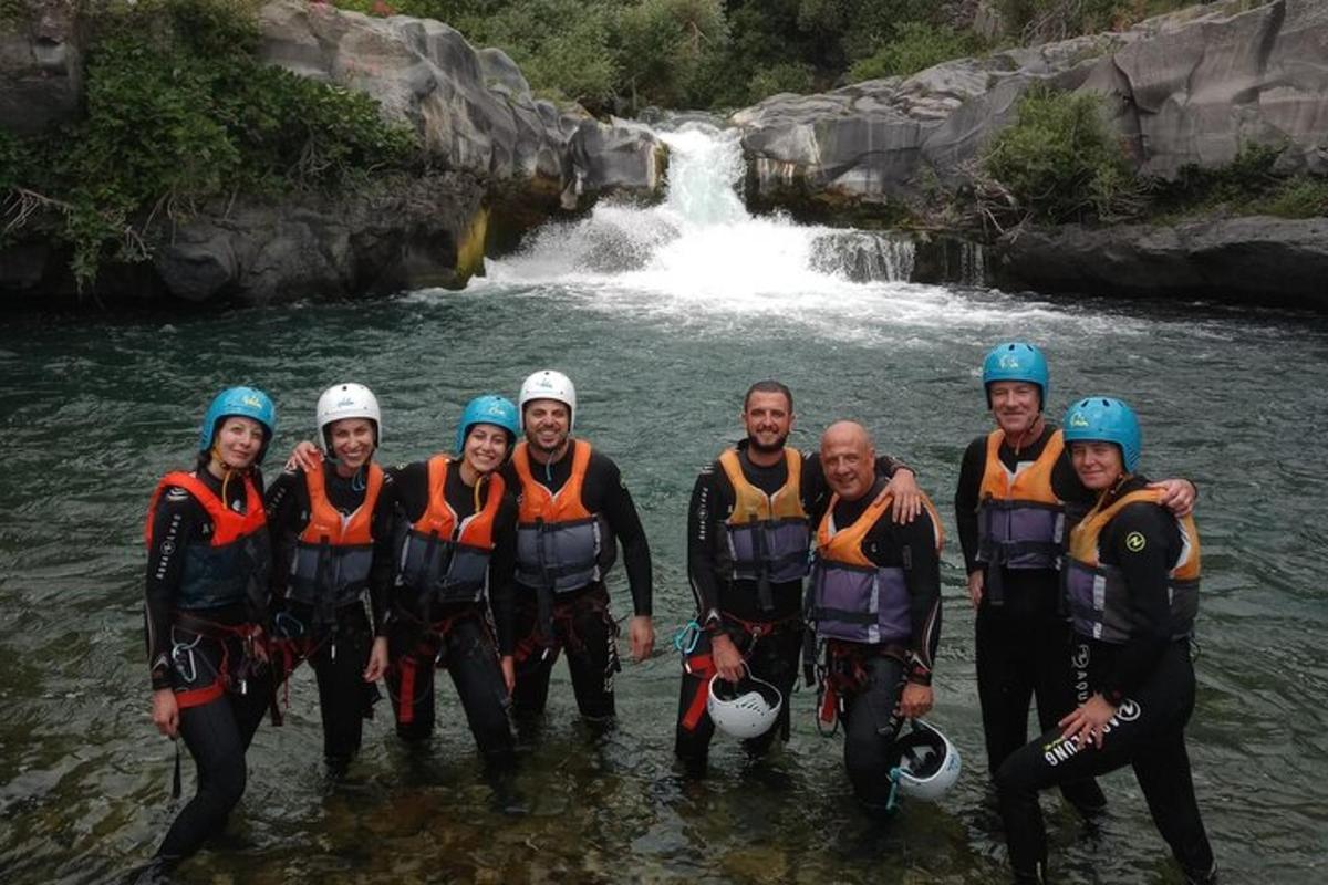 un gruppo di persone in piedi nell'acqua di fronte a una cascata