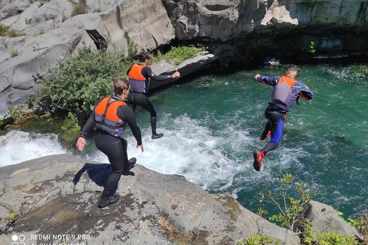 un gruppo di persone che saltano in un fiume