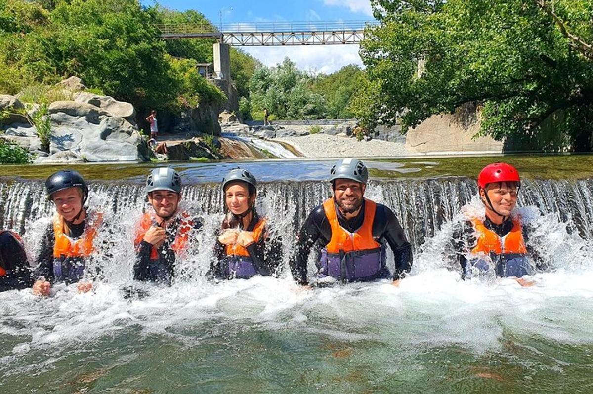 un gruppo di persone in acqua davanti a una cascata
