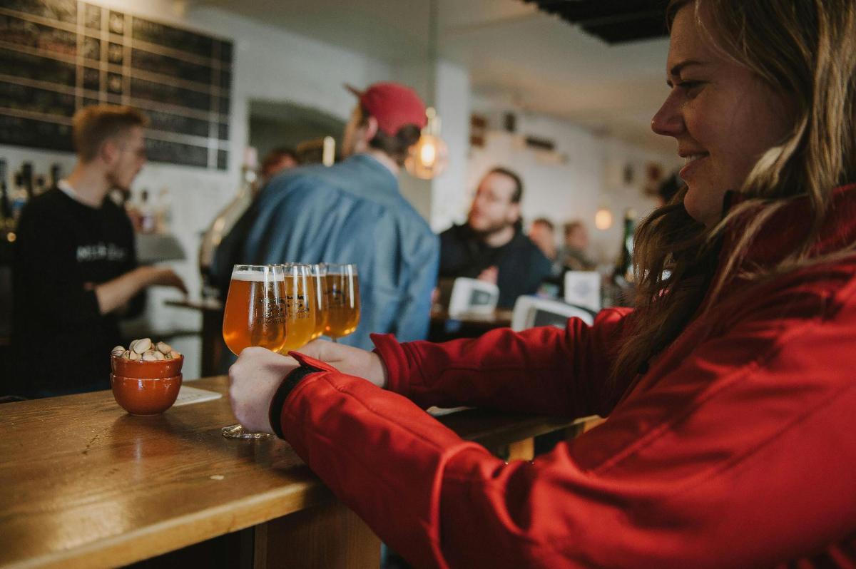 a woman sitting at a bar holding a glass of beer