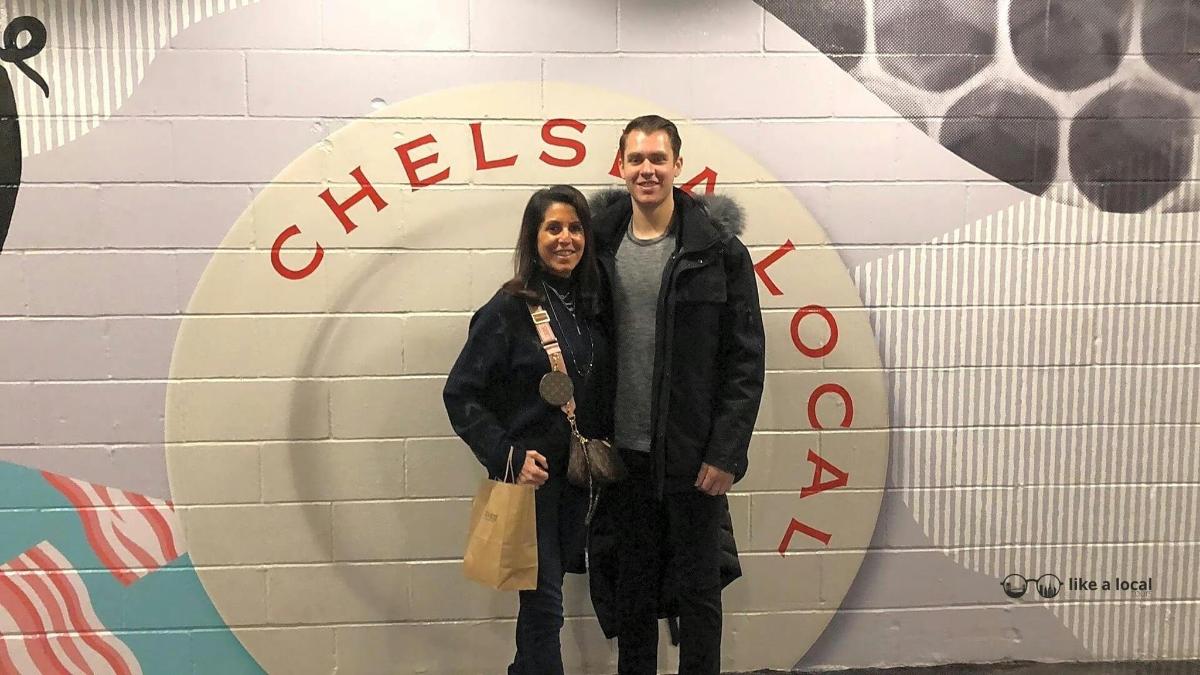 Un hombre y una mujer de pie frente a una pared