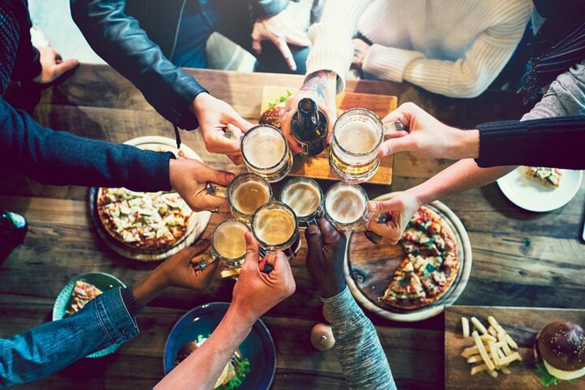 Un grupo de personas sentadas alrededor de una mesa bebiendo cerveza.