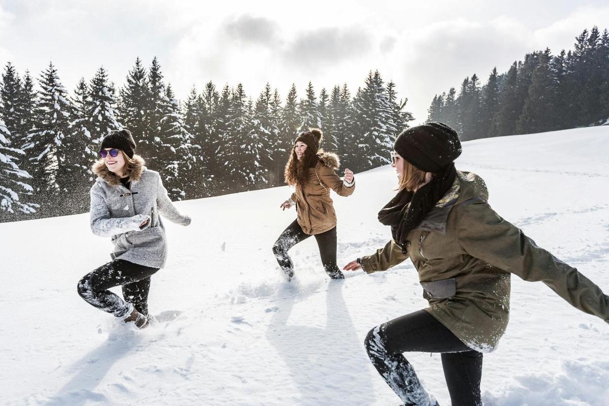 three women are playing in the snow