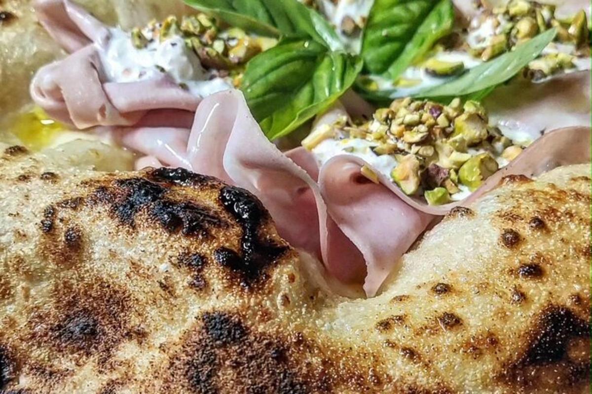 un primo piano di una pizza con verdure sopra