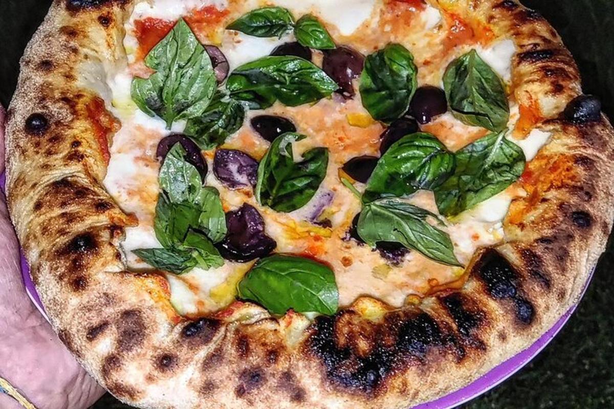 una pizza con foglie verdi su un piatto viola