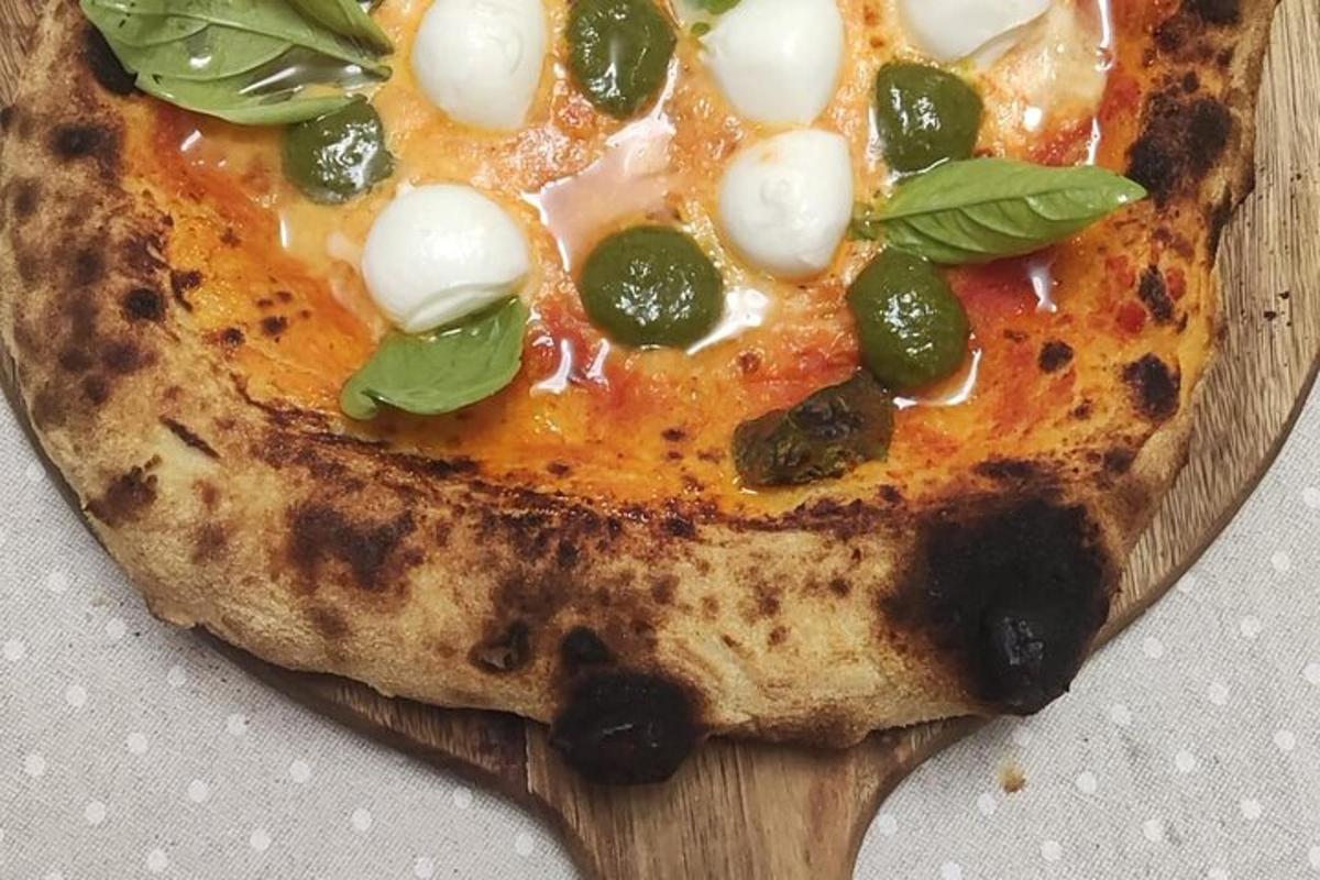 een pizza die bovenop een houten snijplank ligt