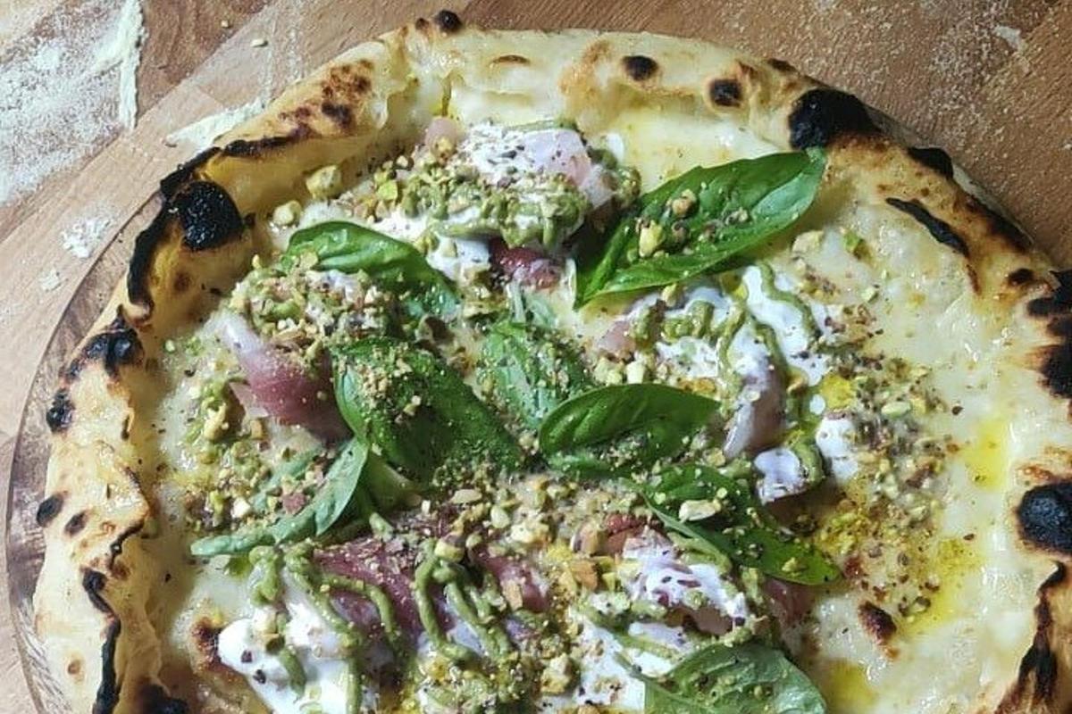 una pizza appoggiata su un tavolo di legno