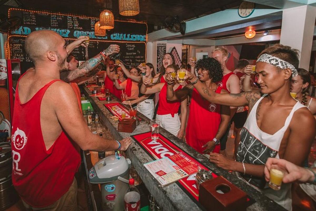 飲み物を飲みながらバーの周りに立っている人々のグループ