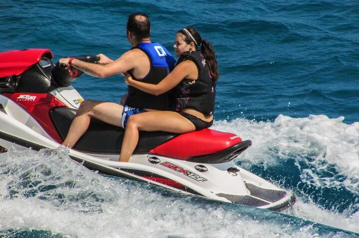 Dos personas viajando en una moto acuática en el agua