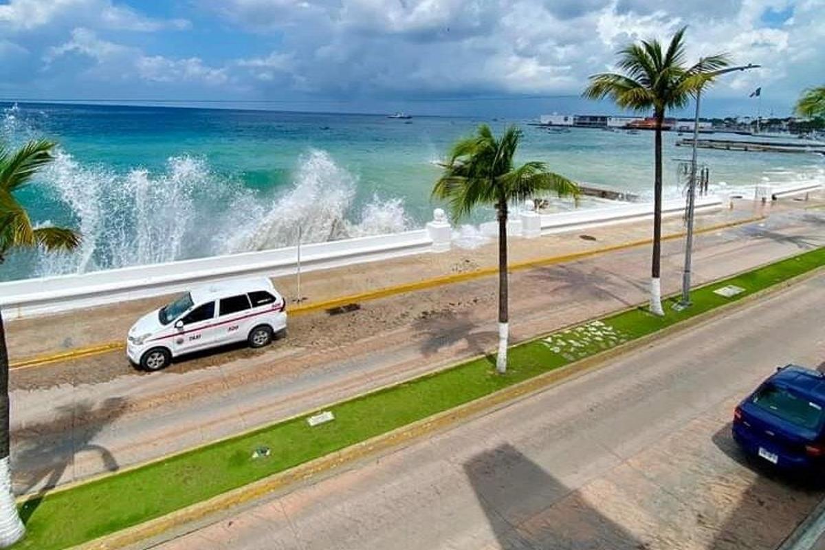 um carro branco estacionado em uma estrada próxima ao oceano