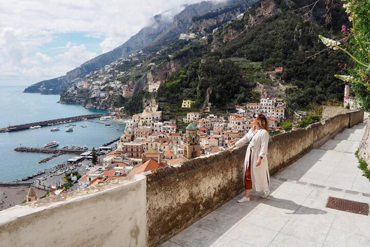 a woman standing on a ledge looking at a city