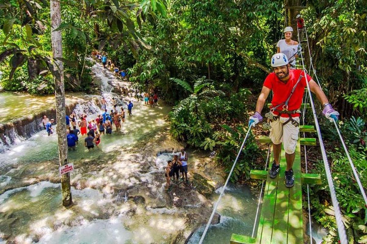 seorang lelaki berdiri di atas jambatan tali di atas air terjun