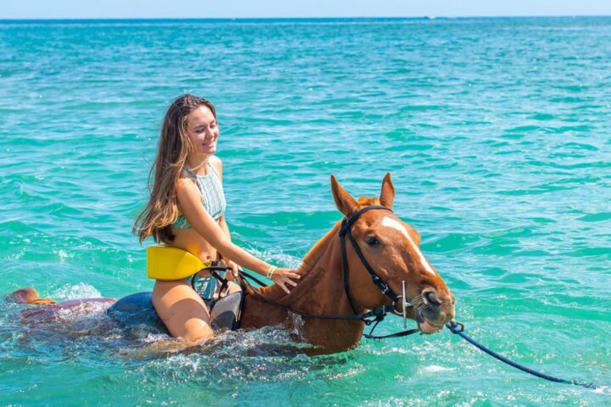a young girl riding a horse in the water