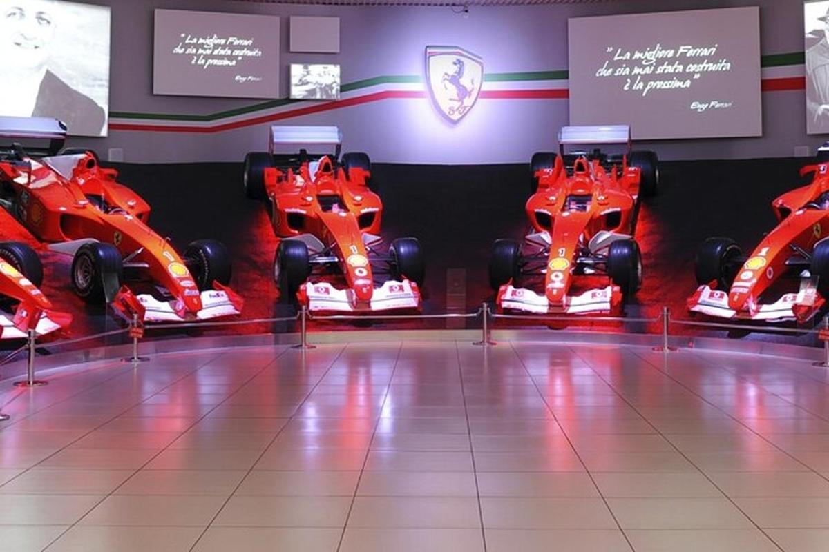 een kamer met twee rode raceauto's tentoongesteld