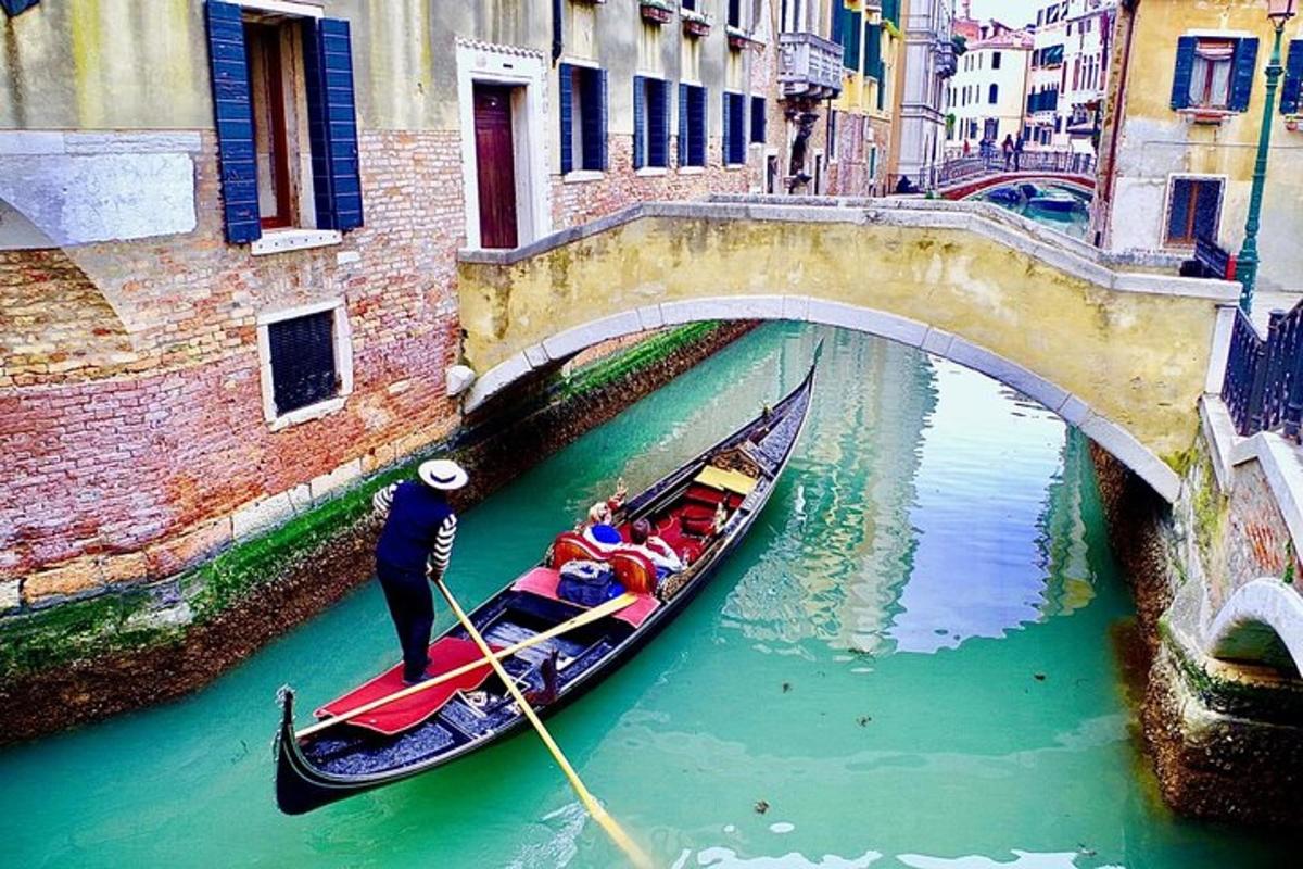 sekelompok orang di gondola di bawah jembatan