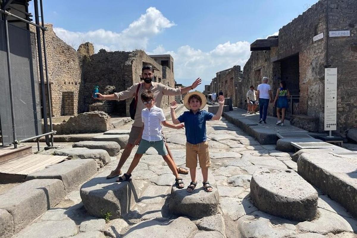 muž a dvaja chlapci stojaci na skalách na ulici
