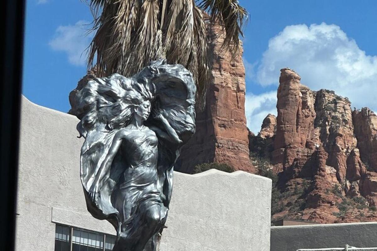 una statua di una donna davanti ad alcune rocce
