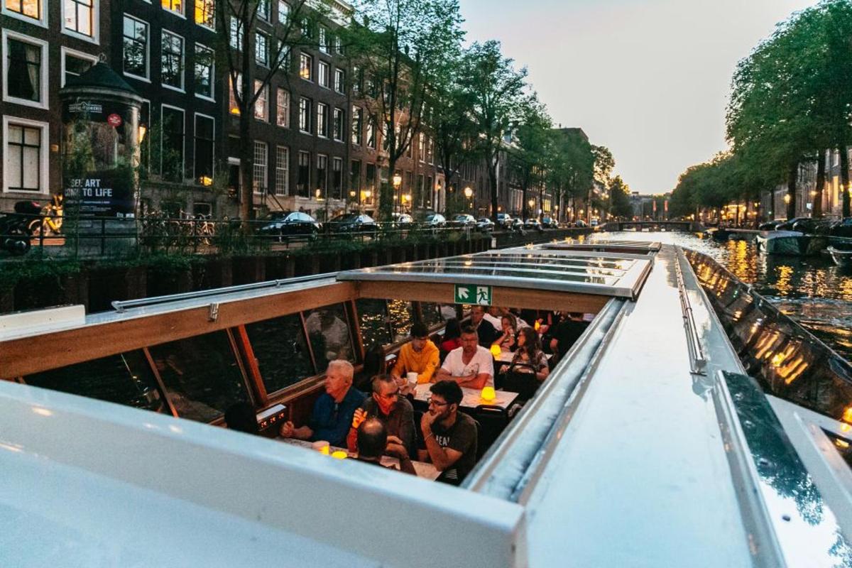 a group of people riding on a boat down a canal