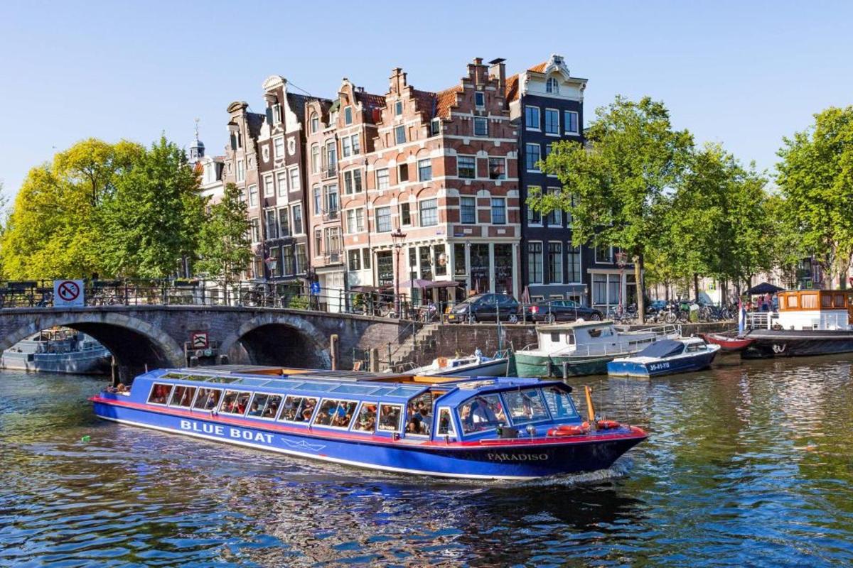 a boat traveling down a river in front of buildings