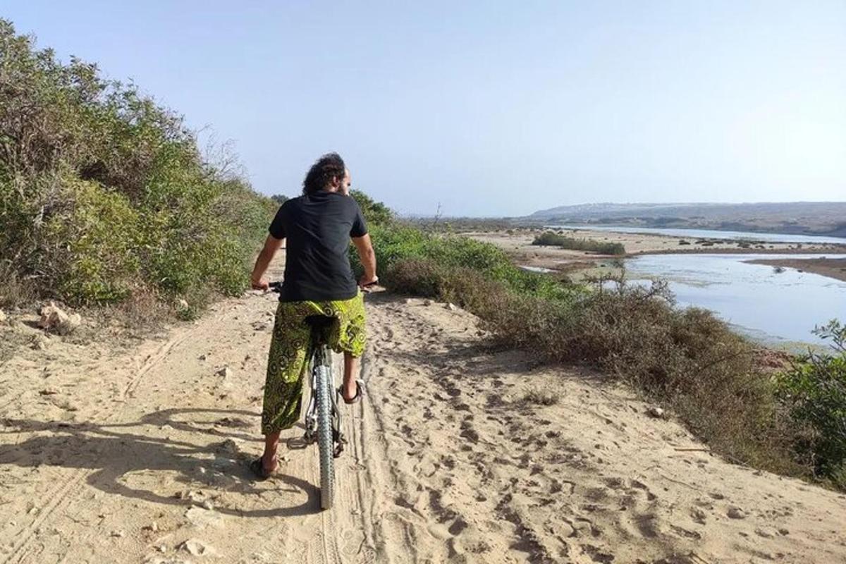 um homem andando de bicicleta em uma estrada de terra