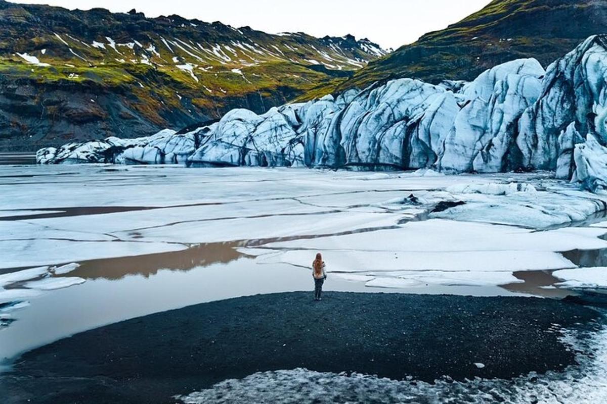 a person standing on the ice in front of a glacier