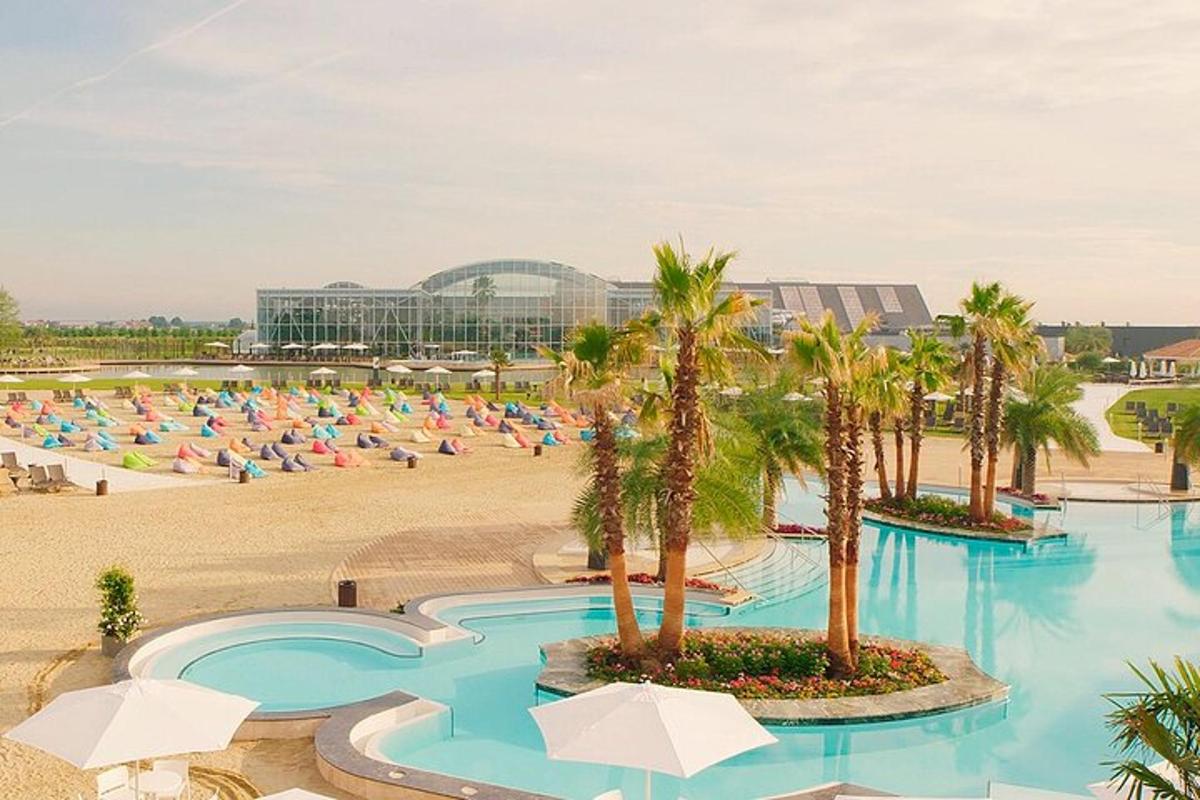 un resort con spiaggia con palme e ombrelloni