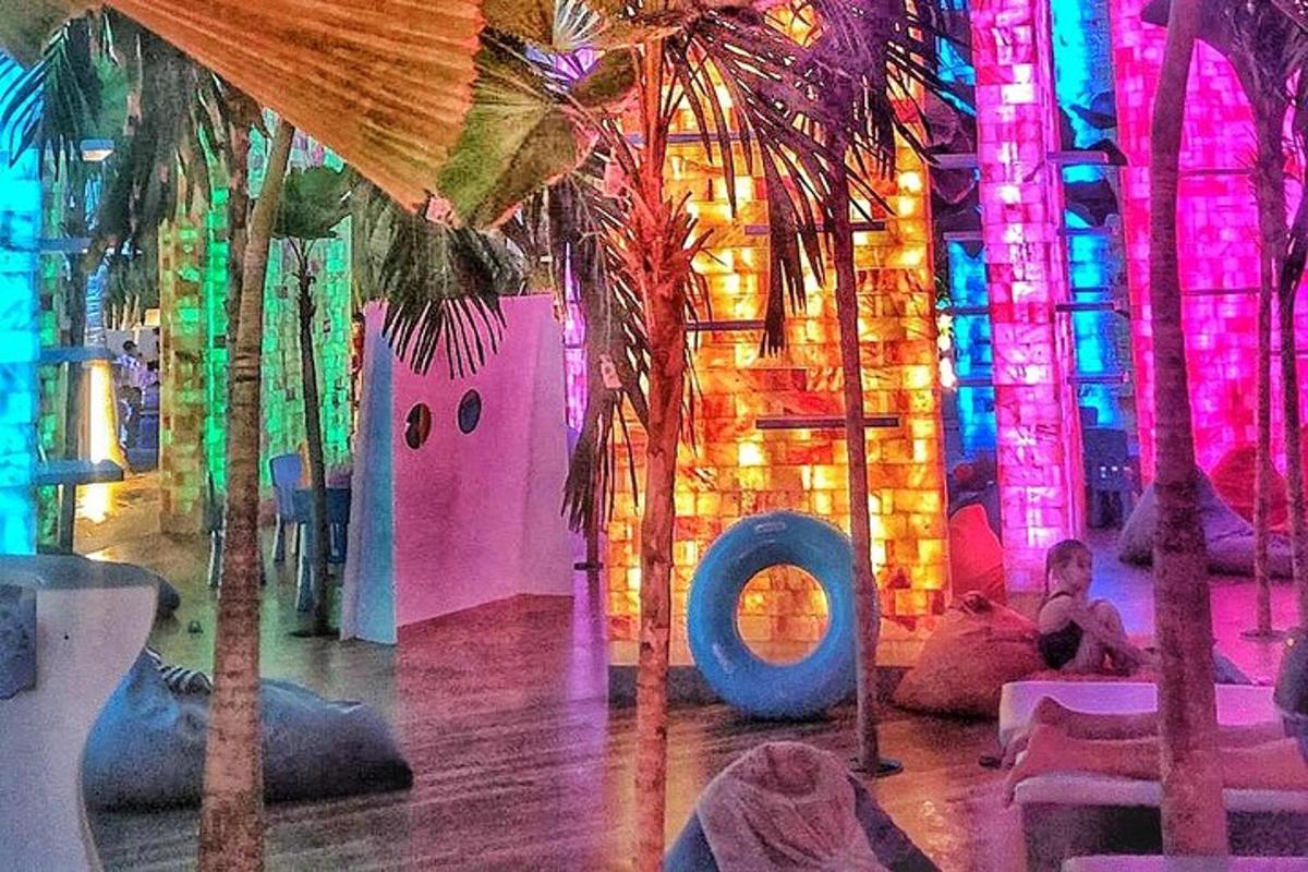 una stanza con palme e luci colorate