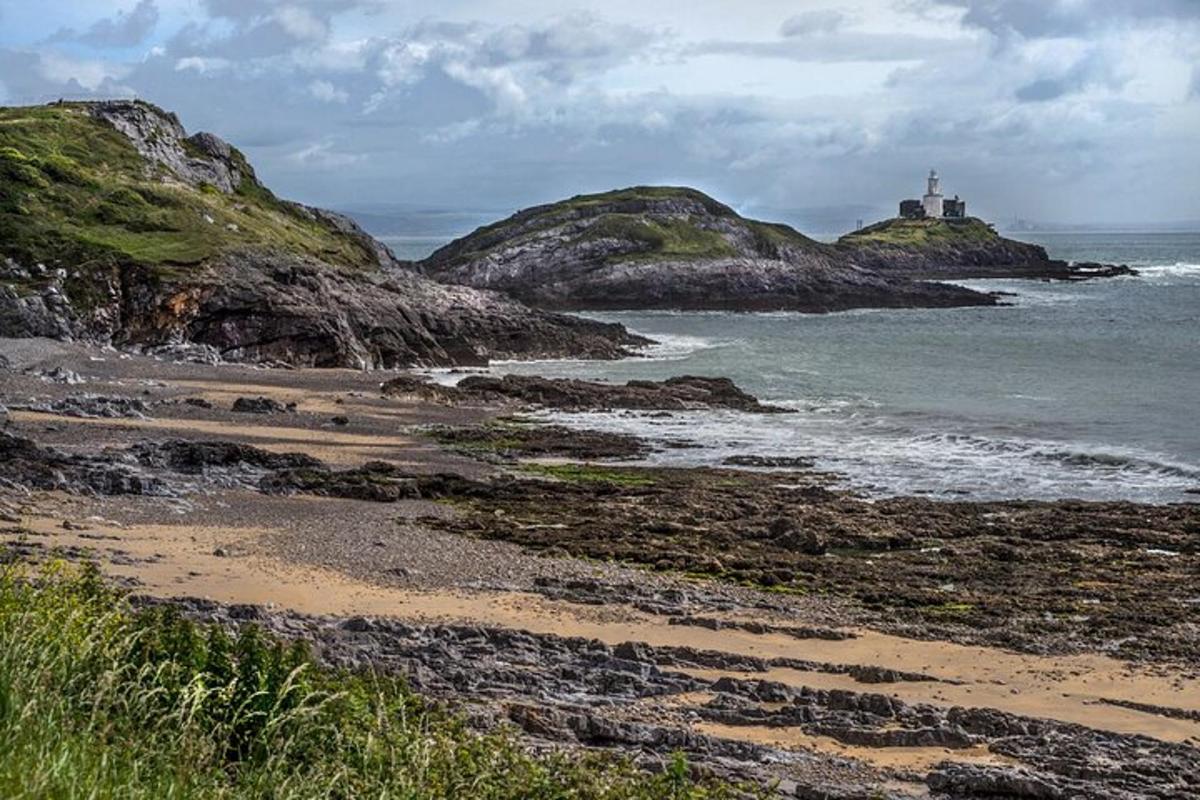 a view of a beach with a lighthouse in the ocean