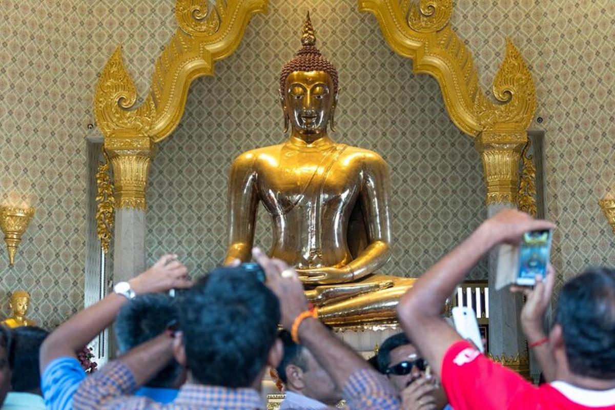 sekumpulan orang mengambil gambar patung emas