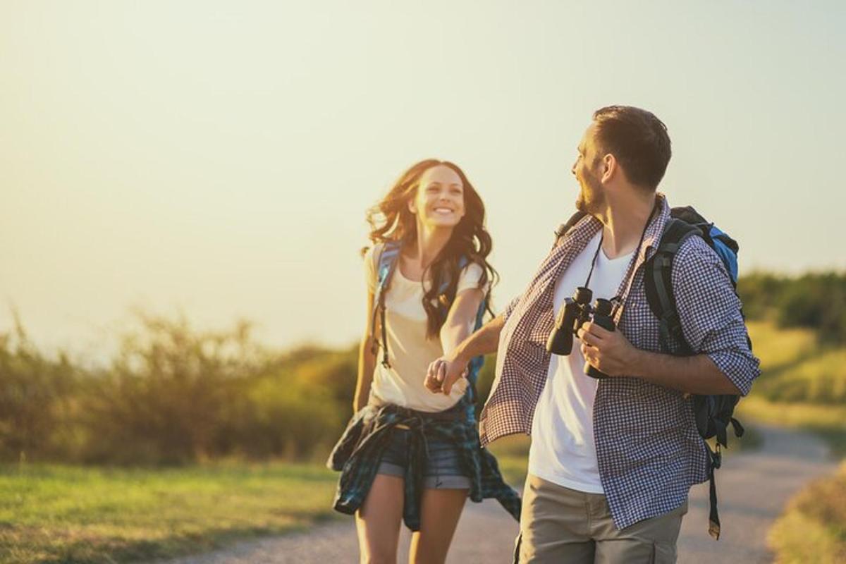 a man and a woman walking down a road with a camera