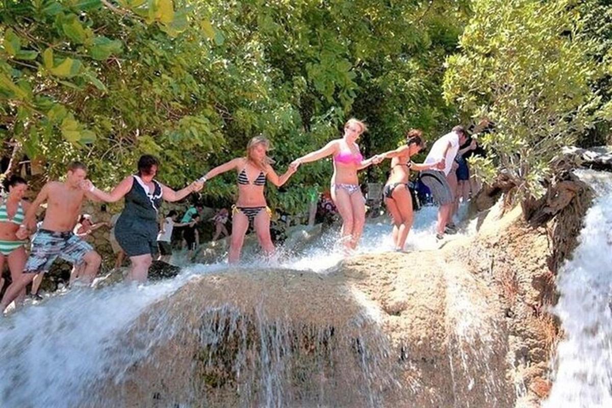 un gruppo di persone in costume da bagno in piedi intorno a una cascata