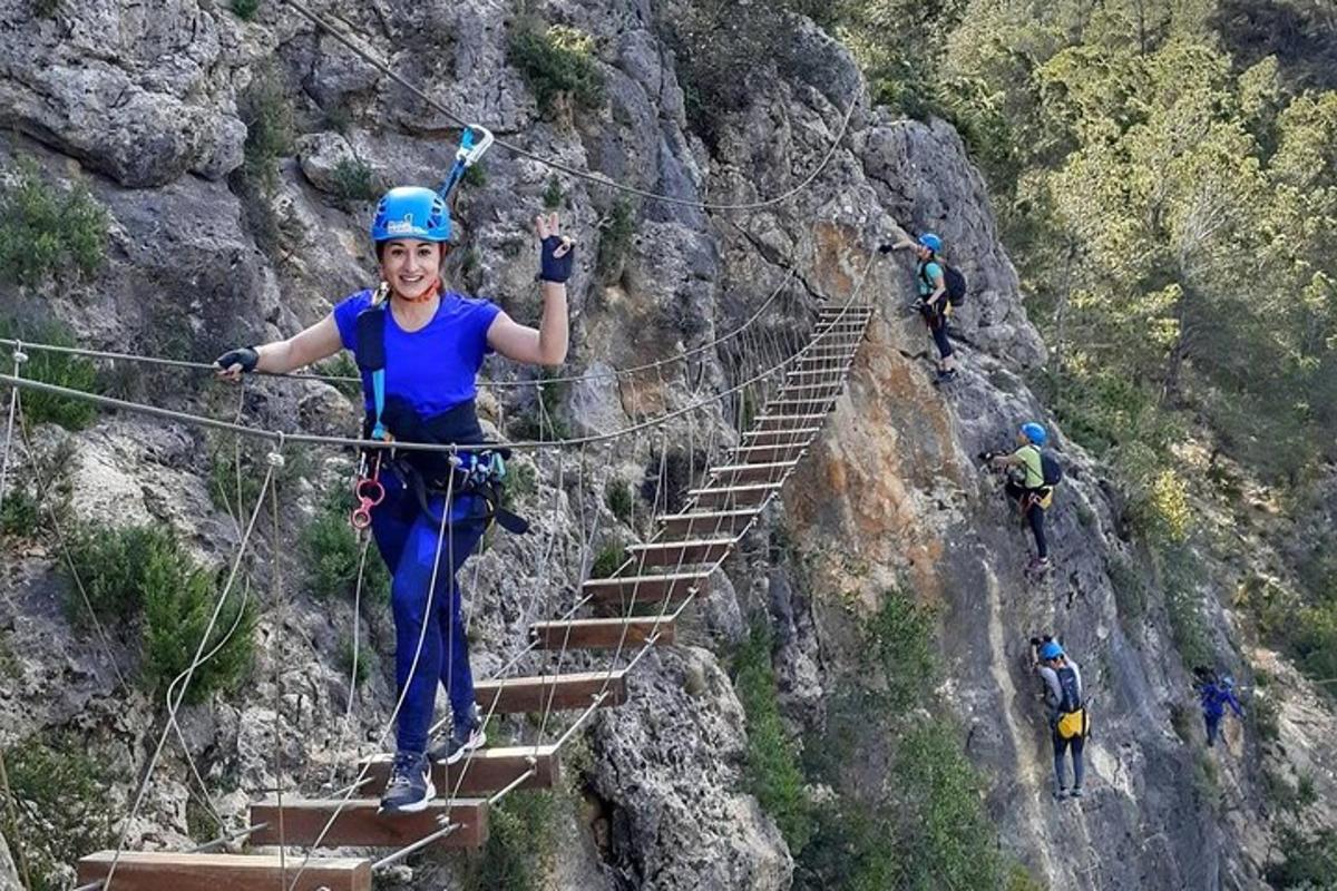 una mujer en un puente de cuerda en una montaña