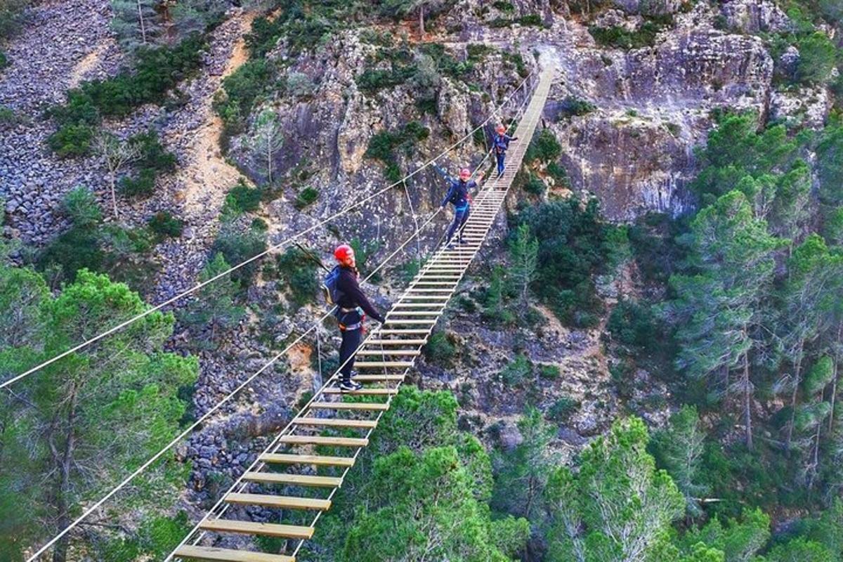 Δύο άνθρωποι περπατούν σε μια γέφυρα από σχοινί πάνω από μια σκάλα