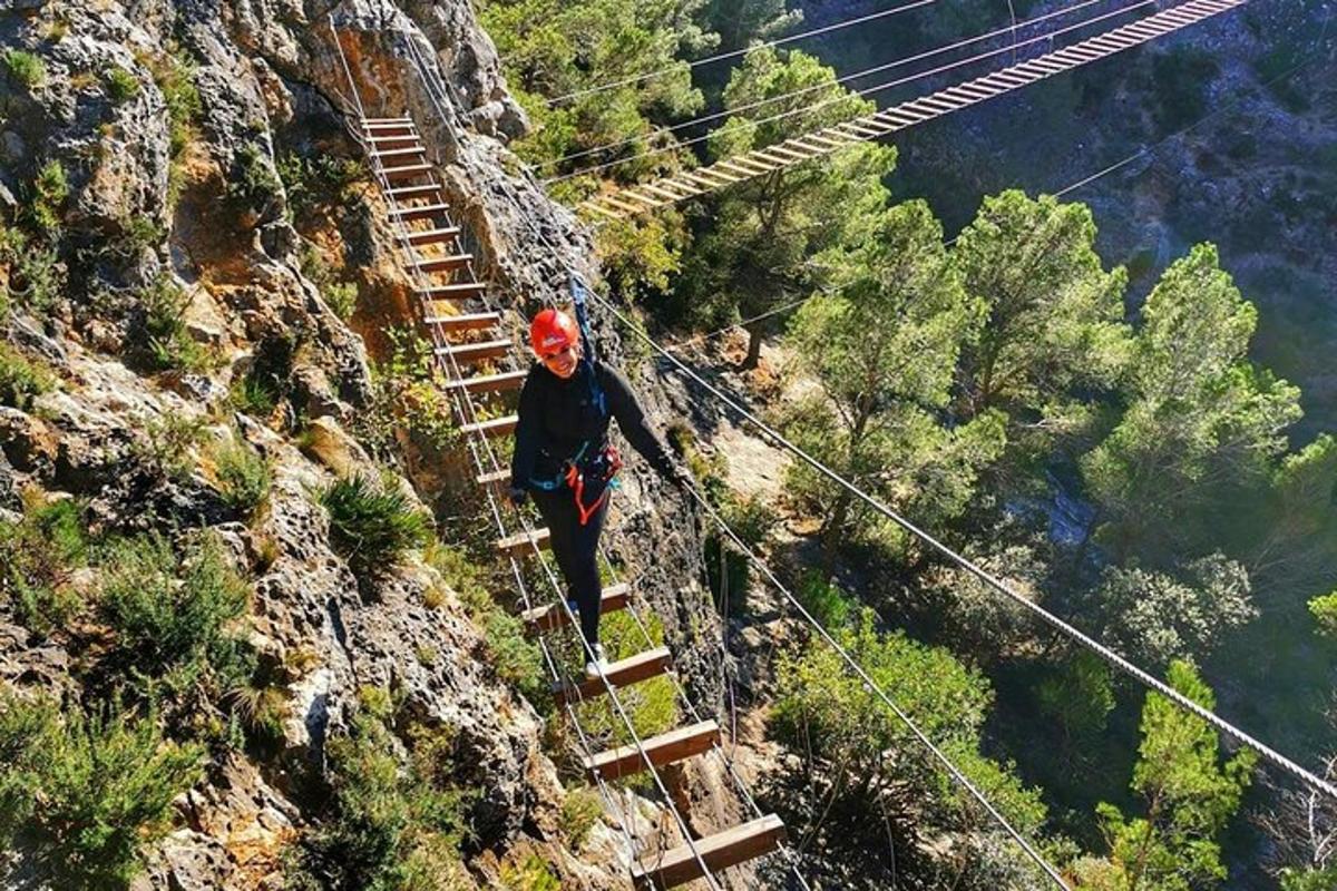 una persona caminando sobre un puente colgante en una montaña