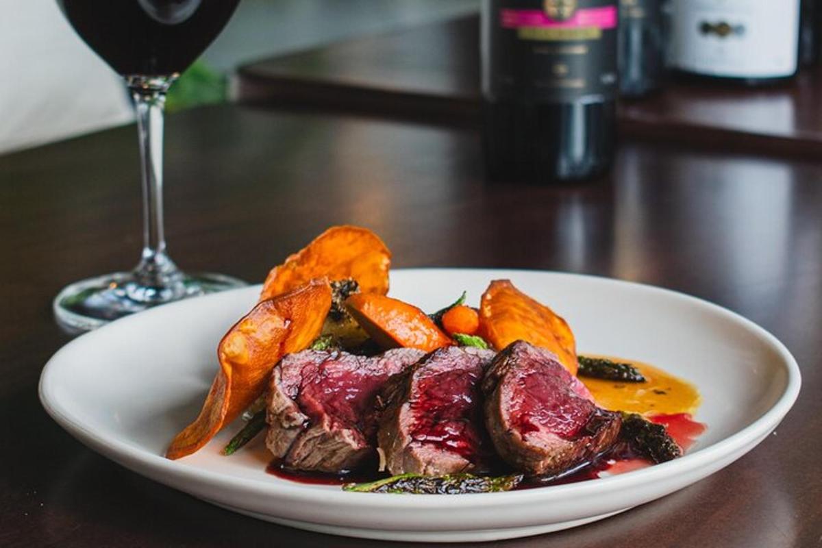 a plate of food on a table with a glass of wine