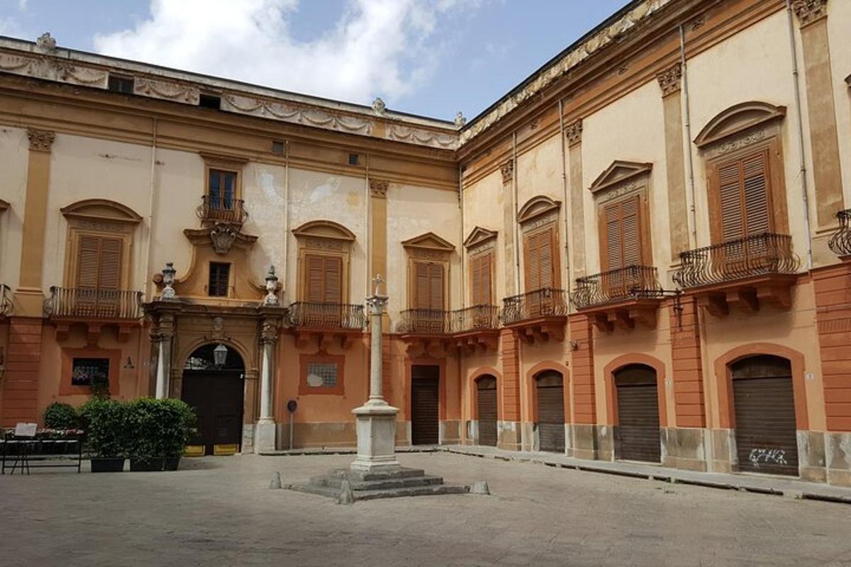 un grande edificio con una colonna in un cortile