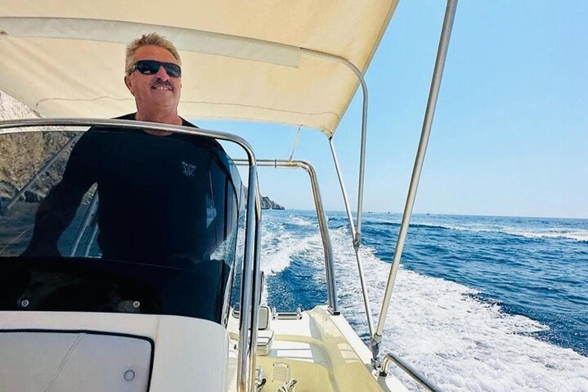 un hombre sentado en un barco en el océano