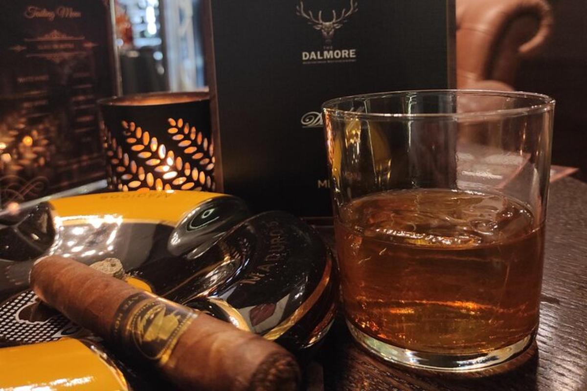 sklenice alkoholu s doutníkem na stole