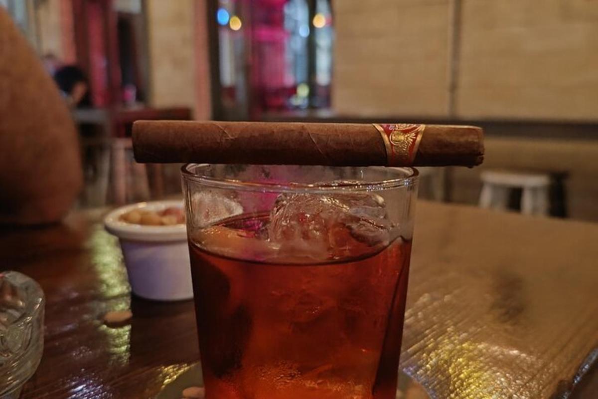 un cigar assegut sobre una beguda sobre una taula