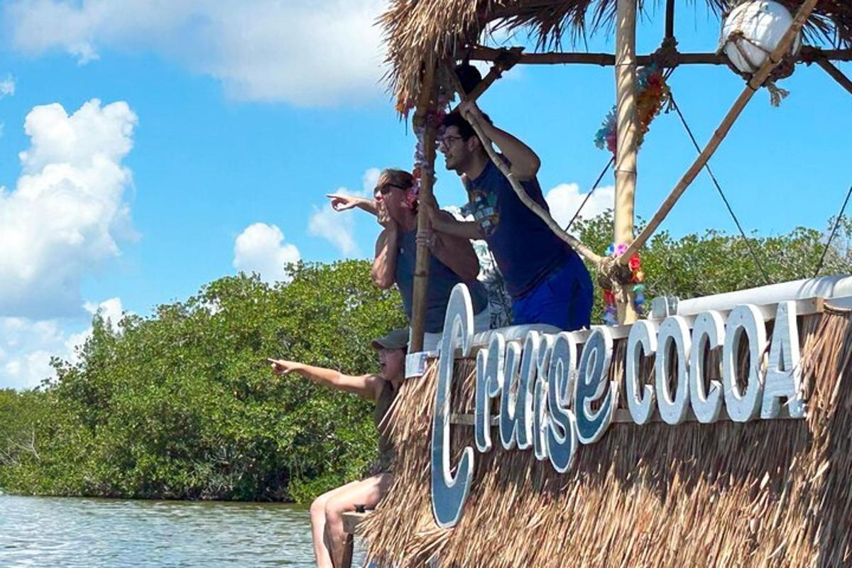 two people sitting on a sign on a boat in the water