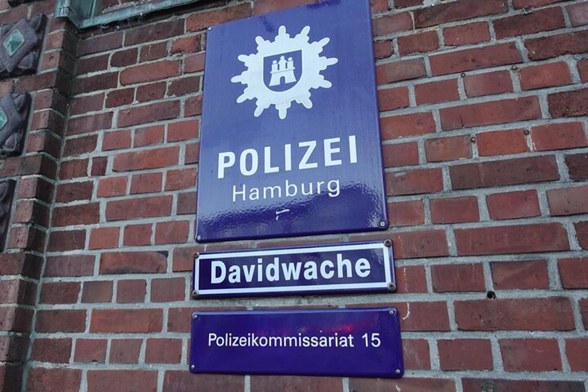 a blue sign on a brick wall with street signs