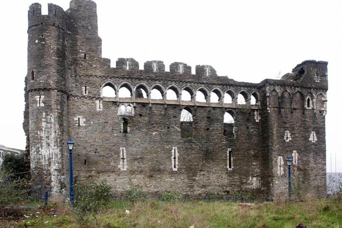 an old brick building with arches on top of a field