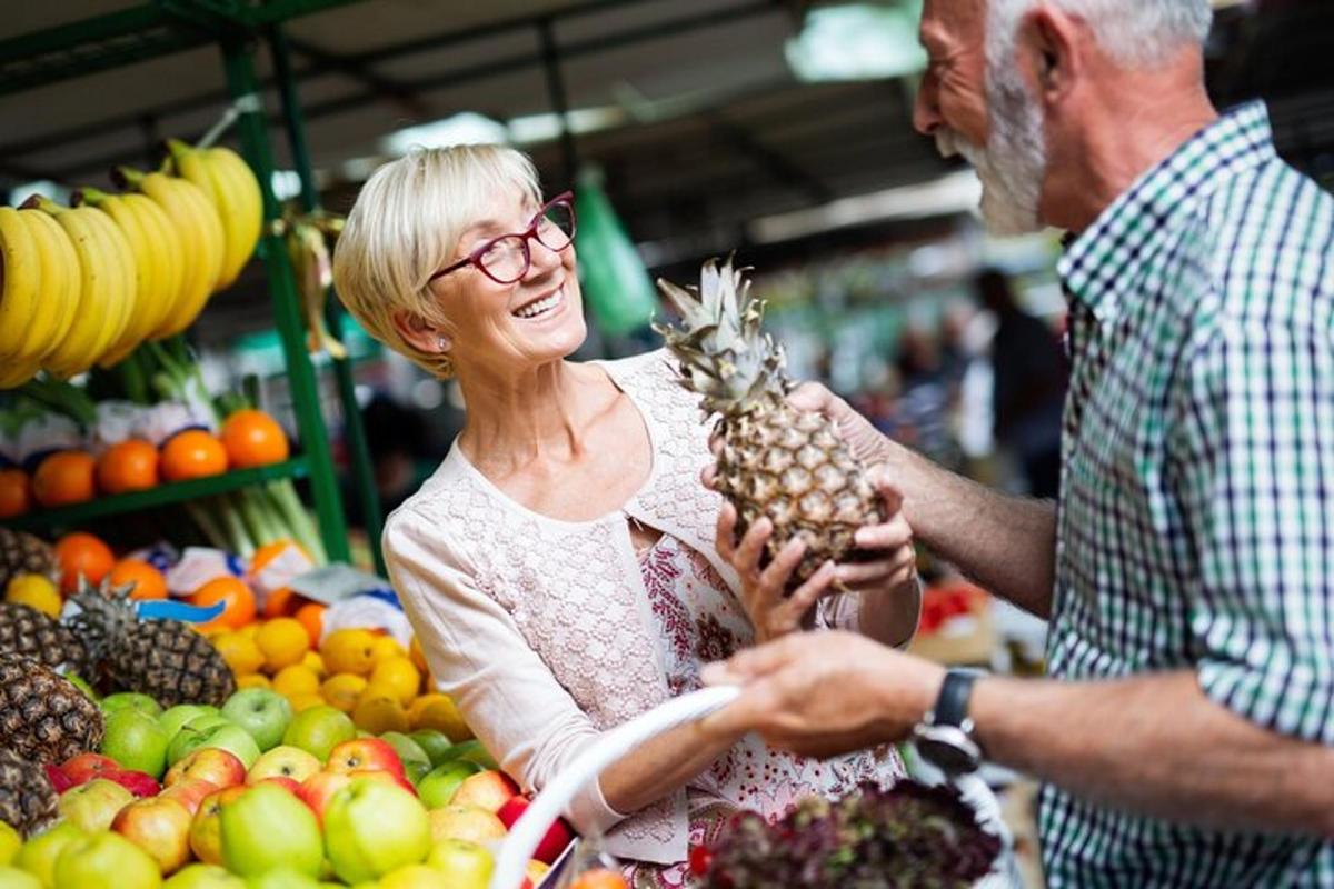 a woman is holding a pineapple in a market