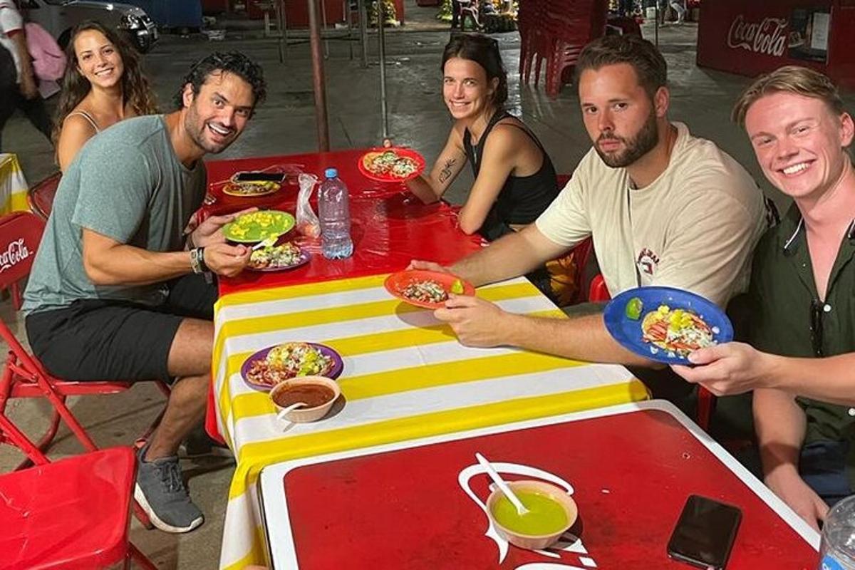 テーブルの周りに座って食事をとる人々のグループ
