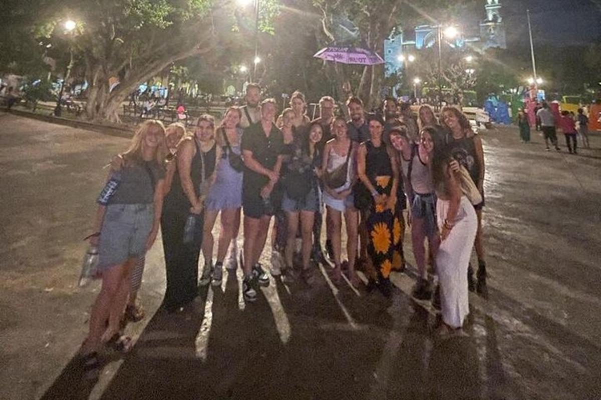 een groep mensen die 's nachts op straat staat