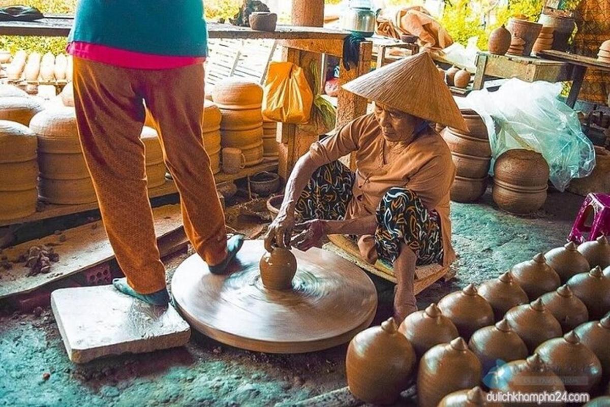 Una mujer está haciendo un jarrón en un torno de alfarero.