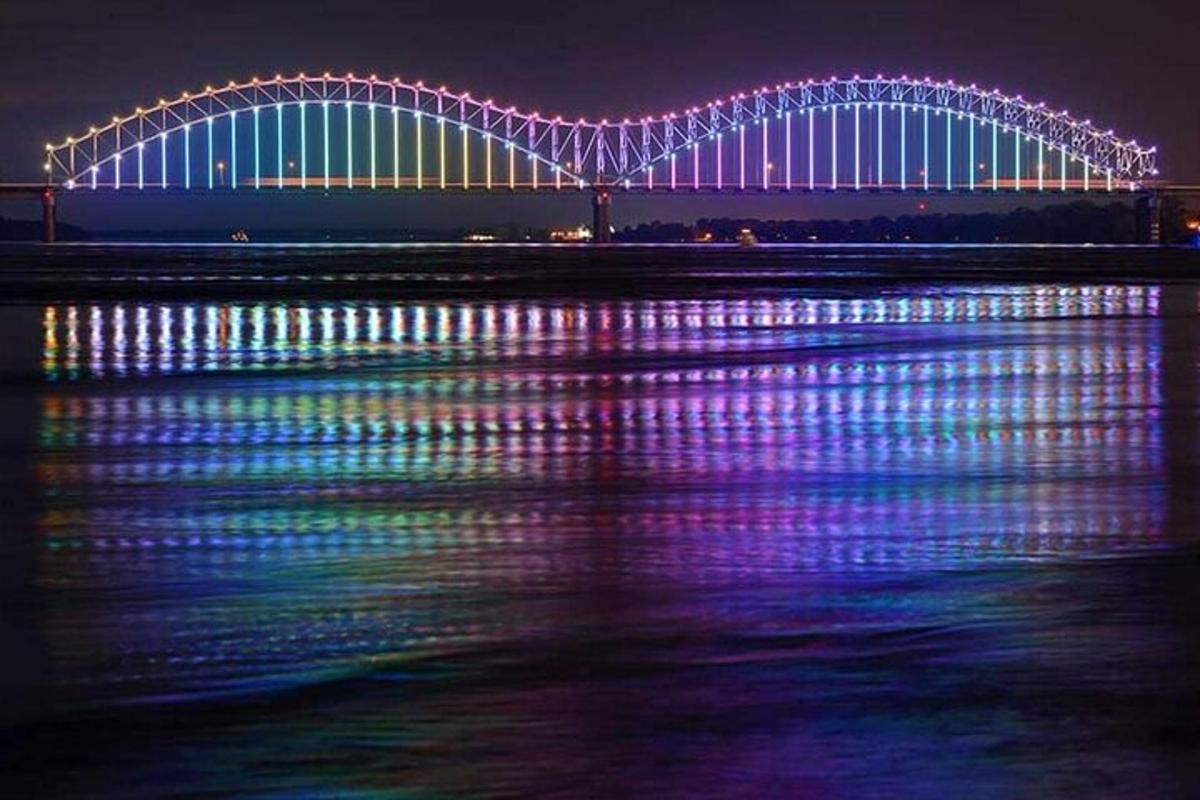 a large bridge with lights on the water at night