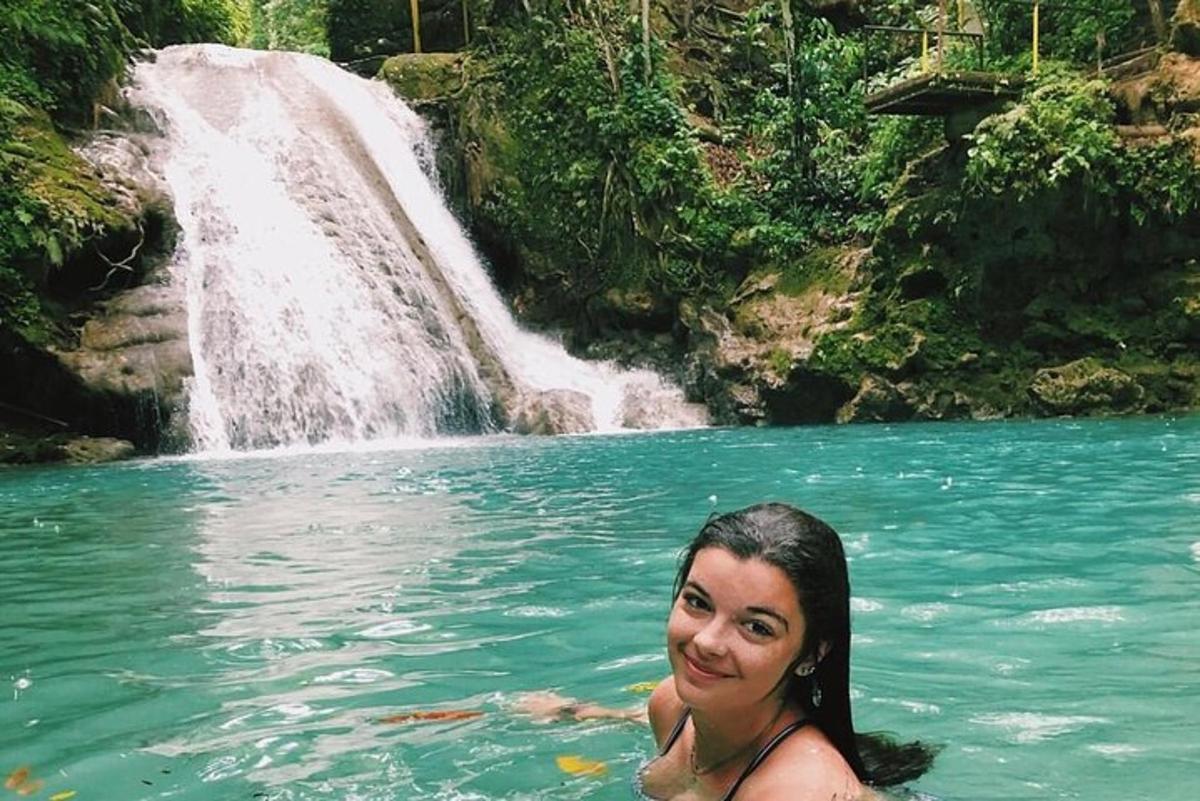 isang babae sa tubig sa harap ng isang talon