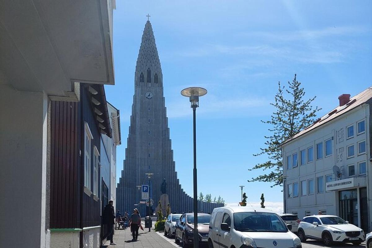 um edifício alto com uma torre de relógio em uma rua da cidade