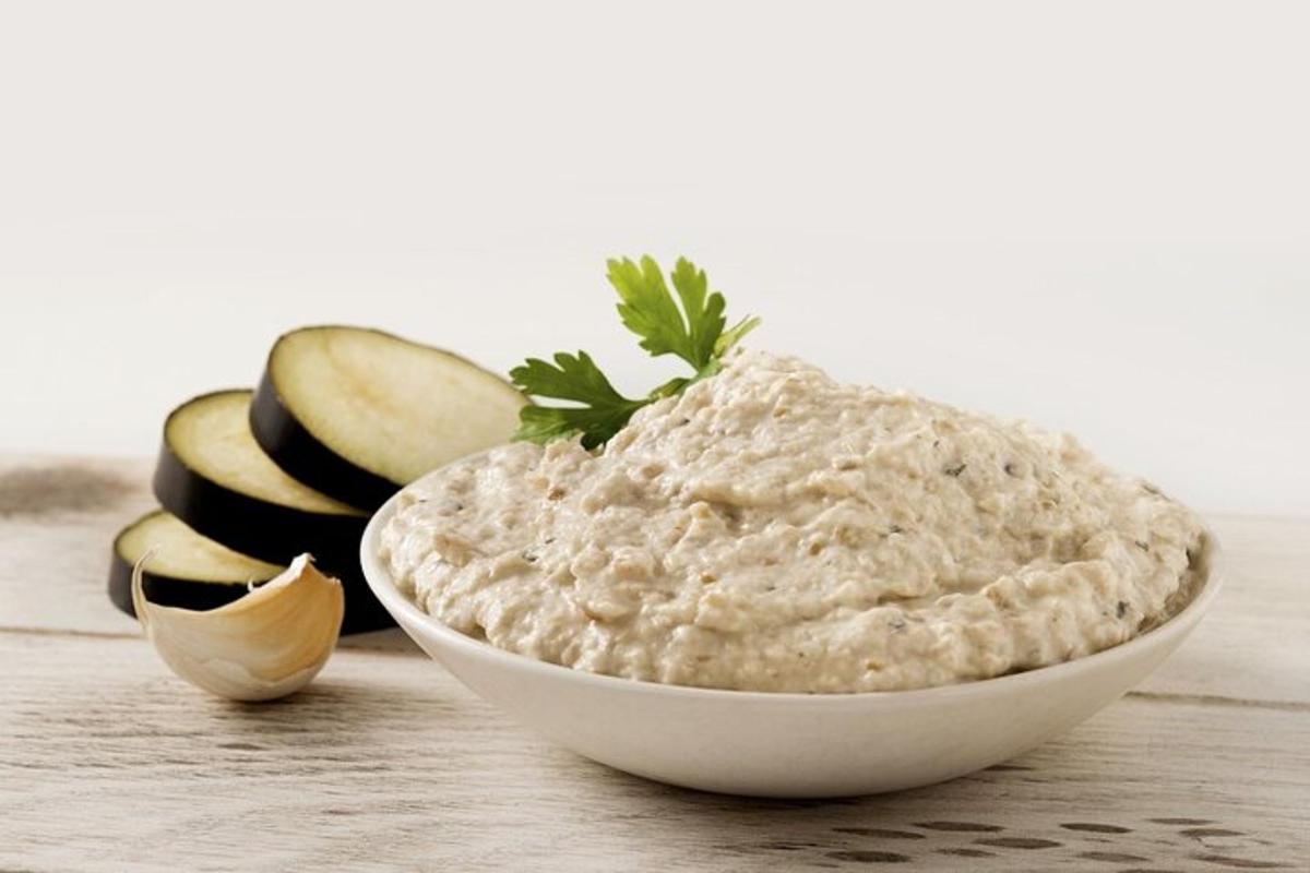 una ciotola di salsa accanto ad alcune mele tagliate a fette